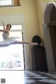 A young ballerina in a white tutu and pointe shoes jumping in the air.