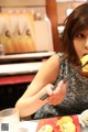 A woman sitting at a table eating food with chopsticks.