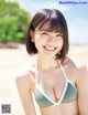 A woman in a bikini standing on a beach.