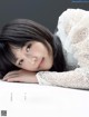 A woman laying on top of a white table.